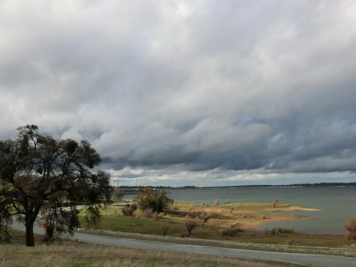 Storm clouds over Folsom Lake at Folsom Point with an oak on the shore